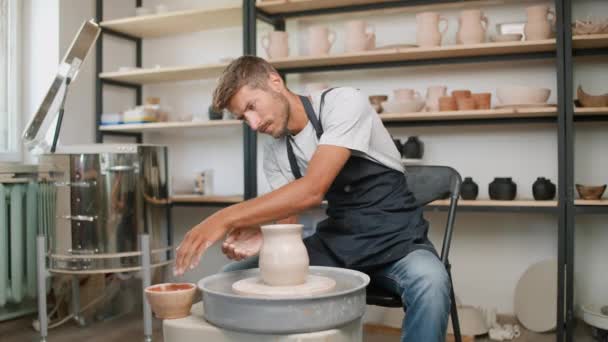 Taller de cerámica, ceramista hombre hace una jarra de arcilla, artesanía, producción de vajilla hecha a mano. — Vídeo de stock