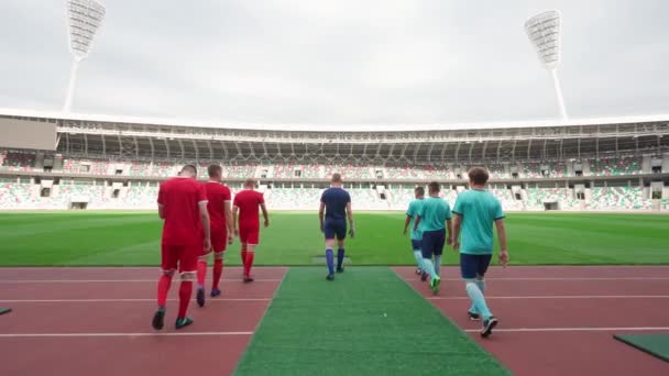 Giocatori di calcio professionisti cammina allo stadio, squadre di calcio rivali camminano attraverso lo stadio, vista posteriore, 4k rallentatore. — Video Stock
