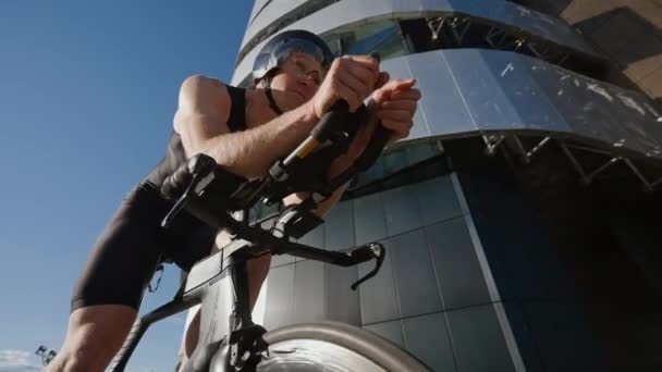 Radprofi fährt auf einer Stadtstraße, Sportler trainiert in einer städtischen Umgebung auf einem Schneiderad, moderne Stadtlandschaft, 4k Zeitlupe. — Stockvideo