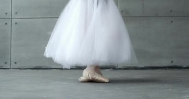 Beyaz etekli bir kadın, dans balesi ve Pointe ayakkabılarıyla denge, bacak manzarası, beyaz arka plan, prova.
