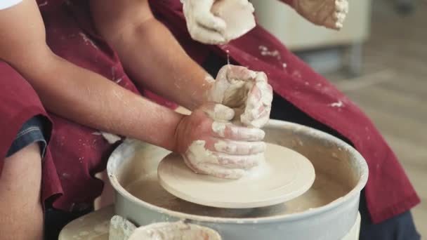 Vue de dessus, production de vaisselle artisanale, le jeune couple potier fait un pichet en argile, vue rapprochée des mains, artisanat, atelier de poterie. — Video