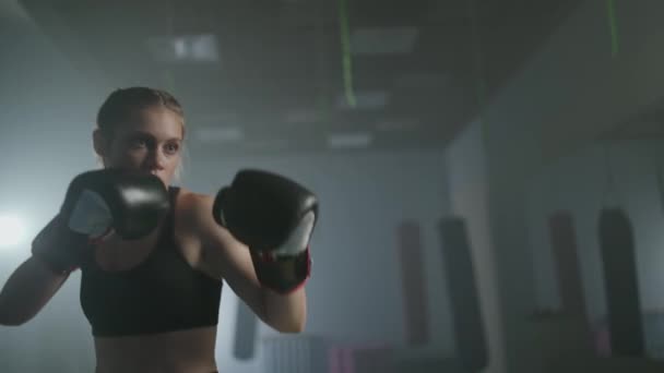 Πυγμαχία, γυναίκα μαχητής εκπαιδεύει γροθιές του, κτυπά ένα σάκο του μποξ, ημέρα κατάρτισης στο γυμναστήριο πυγμαχίας, δύναμη ταιριάζει σώμα, το κορίτσι χτυπά γρήγορα. — Αρχείο Βίντεο