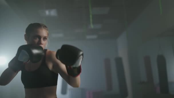 Box, luptător de sex feminin trenuri pumni lui, bate un sac de perforare, zi de antrenament în sala de sport de box, corp de forță se potrivesc, fata lovește rapid. — Videoclip de stoc