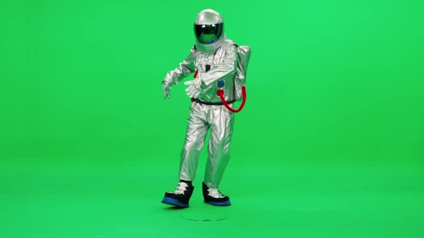 Bielorrússia, Minsk - 13 de setembro de 2021: Homem em um traje de astronauta se move e dança em um fundo verde, modelo de cromo, câmera lenta 4k. — Vídeo de Stock