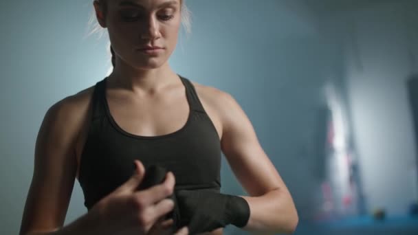 女战士用拳击绷带包裹着双手，在体育馆里练跆拳道，女战士在准备战斗，4K慢动作. — 图库视频影像