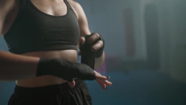 Vrouw vechter wikkelt haar handen met boksverband, kickbokstraining dag in een sportschool, vrouwelijke vechter bereidt zich voor op de strijd, 4k slow motion. — Stockvideo