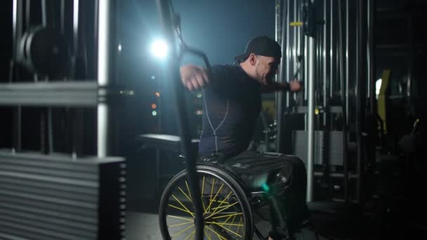 Dayanıklılık, tekerlekli sandalyedeki engelli atlet raf makinesindeki engelleri kaldırma, blok cihazındaki güç eğitimi, engelli insanlar, 4k ağır çekim. — Stok video