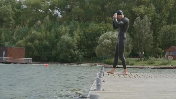 Nuotatore professionista in muta salta in mare aperto, triatleta si allena prima di una gara di triathlon, 4k super slow motion. — Video Stock