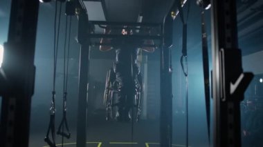 Yavaş çekim, tekerlekli sandalyedeki engelli sporcu yatay barfiks çekiyor, kendine sıkı çalışıyor, engelli insanlar....