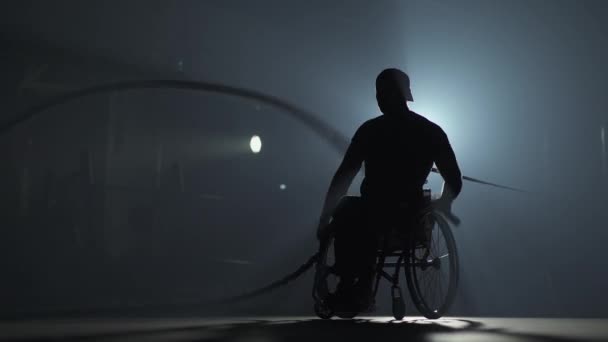 Niepełnosprawny mężczyzna na wózku inwalidzkim, wykonuje ćwiczenia z linami bitewnymi, trening wytrzymałościowy, trening siłowy i aktywność fizyczną. — Wideo stockowe