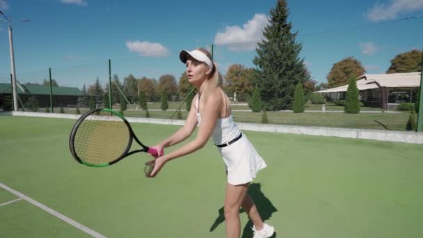 Pro tennisspelare träffar bollen med ett racket, öva spel på tennisbanan, kvinnlig portion boll under tennismatch, 4k slow motion. — Stockvideo