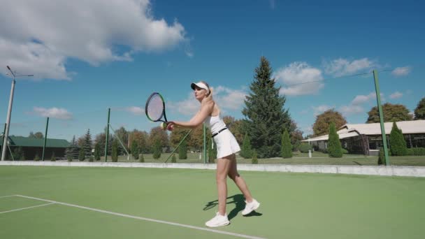 Profesionální ženský tenista odpaluje míček raketou, cvičná hra na tenisovém kurtu, servíruje míček během tenisového zápasu, Super zpomalený film. — Stock video