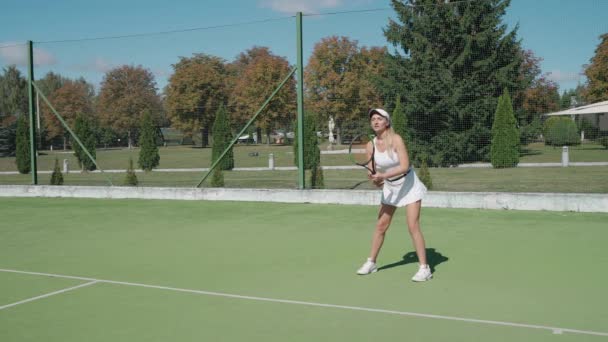 Zwolniony ruch, profesjonalna tenisistka uderza piłkę rakietą, gra ćwiczyć na korcie tenisowym, uderza przeciwników służyć podczas meczu tenisowego. — Wideo stockowe
