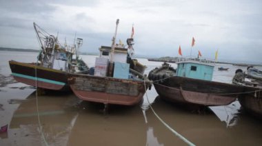 Mumbai 'de terk edilmiş bir iskelenin manzarası. Deniz kıyısına yayılmış balıkçı tekneleri ve enkazlar..