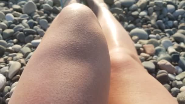 Mulher deitada na praia, pernas femininas relaxantes no pôr do sol à beira-mar, pontos de vista — Vídeo de Stock