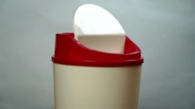 throw money away, female hand putting 100 euro banknote into the dustbin