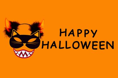 Vampir gülüşlü kedi canavarın komik yüzü, turuncu arka planda başlık boynuzları. Kağıt dekor, siyah yazıtlı fotoğraf aksesuarları tuval üzerinde mutlu cadılar bayramı. Kutlama için parti aksesuarı.