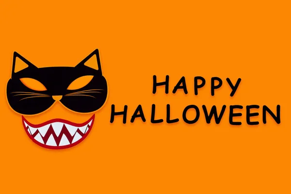 オレンジの背景に吸血鬼の笑顔の歯を持つ猫モンスターの面白い顔 紙の装飾 キャンバス上の黒い碑文幸せなハロウィンと写真の小道具 パーティー お祝いのためのカーニバルアクセサリー — ストック写真