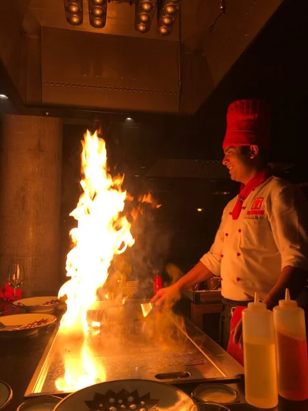 Šéfkuchař vaření sushi s ohněm dělat show cooking Royalty Free Stock Fotografie