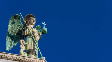 Başmelek Aziz Mikail, ortaçağdan kalma bir 13. yüzyıl heykeli olan Ejderhayı yener ve Lucca 'daki Aziz Michael Kilisesi' nin tepesini (kopya uzayı ile) yener.)