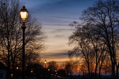 Lucca 'da kış ve romantizm. Günbatımı gökyüzü olan antik duvarlar sokak lambaları