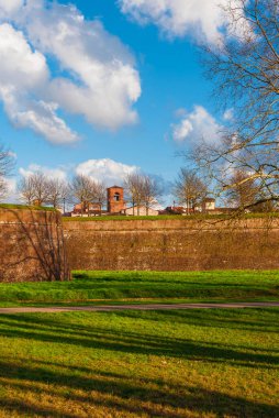Lucca 'da kış. Çıplak ağaç dallarıyla antik şehir duvarlarının manzarası