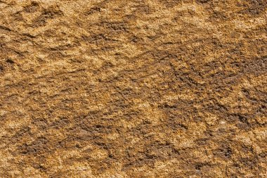 Arkaplan olarak kaba yüzeyi olan kahverengimsi taş