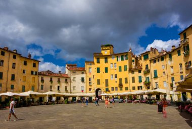 Lucca, ITALY, 14 Temmuz 2021 - Lucca 'nın tarihi merkezinde tarihi Roma harabeleri üzerine inşa edilmiş evler, dükkanlar ve restoranlar ile ünlü Piazza dell' Anfiteatro (Amfitiyatro Meydanı)
