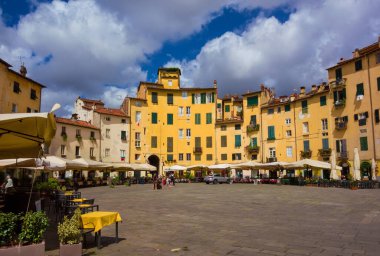 Lucca, ITALY, 14 Temmuz 2021 - Lucca 'nın tarihi merkezinde tarihi Roma harabeleri üzerine inşa edilmiş evler, dükkanlar ve restoranlar ile ünlü Piazza dell' Anfiteatro (Amfitiyatro Meydanı)