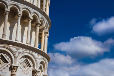 The famous Leaning Tower of Pisa monumental arches with blue sky and white clouds 