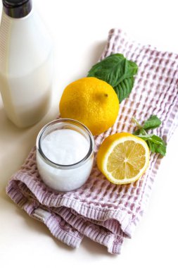 Kompozisyonun ortasında bir pamuk havlu, üzerinde bir krema kavanozu, limon ve nane yaprakları var. Arka tarafta bir şişe merhem var. Kavram: kozmetoloji, kaplıca, tıp.