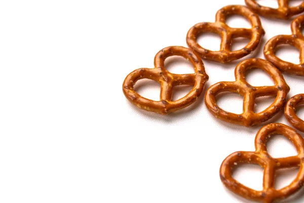 Crispy salty pretzels are laid out on a white background. Top view. Concept: quick snack, food photography, holidays and vacations, cafes and bistros, Christmas food. — Stock Photo, Image