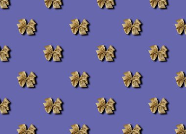 Bir veri peri arka planında hediyeler için altın fiyonk. Güzel bağlanmış bir fiyonk. Kusursuz desenli bir hediye paketinin fotoğrafı..