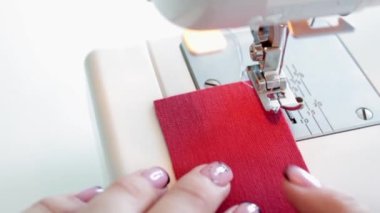 Dikiş makinesinin kumaş parçalarını hazırlama süreci.