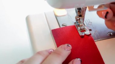 Dikiş makinesinin kumaş parçalarını hazırlama süreci.