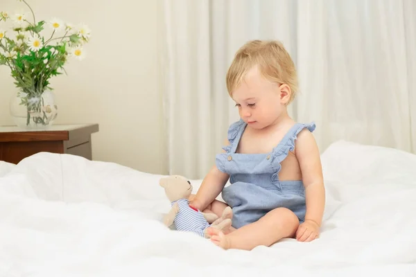 침대에 시트에 아이는 침실에서 부드러운 장난감을 가지고 — 스톡 사진