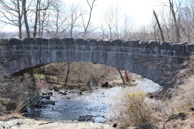 küçük bir dere üzerinde taş köprü
