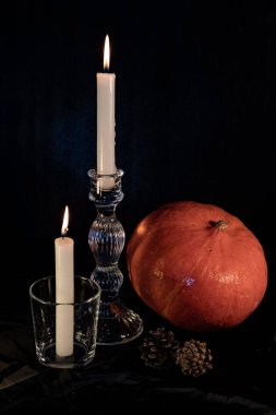 Cam şamdanlarla aydınlatılmış mumlar. Mum ışığı ve turuncu balkabağı, Cadılar Bayramı arifesinde.. 
