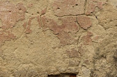 Parçalanmış alçılı eski bir duvar. Çimento alçılı tuğla bir duvar, üzerinde çatlaklar oluşmuş..