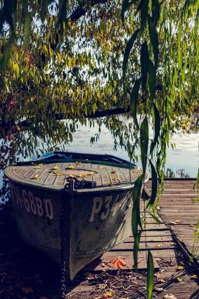 プラットフォーム上の弓にサイドプレートと黄金の葉を持つ緑の漁船 木の下のスチールボートは 太陽の下で 小さな村の漁師の仕事 — ストック写真