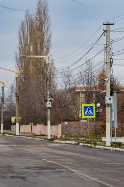 Yol kenarında yaya geçidi olan bir yol geçidi tabelası. Yolu geçmenin gerekli olduğu yeri gösteren bir tabela..
