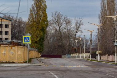 Otoyol boyunca yaya geçidi, bir tabela ve işaretlerle donatılmış. Yaya geçidi, otoyolun karşısında, şehirde, fabrikanın yanında..
