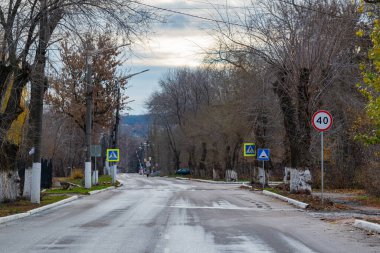 Yolun bir kısmında, şehirde, yol işaretleriyle. Araçların hızını sınırlayan yol işaretleri. Düzenli yaya geçidini gösteren yol işaretleri.