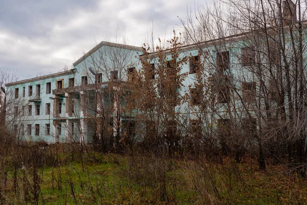 古い荒廃した寮の木で生い茂った 解体を目的とした空の寮 ロシアの珍しい場所にある普通の崩壊した建物 — ストック写真