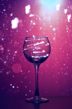 Şeffaf cam bardakta parlayan ışıklar. Cam bir bardakta parlayan çelenkler neşeli bir hava yaratır. Güzel, şeffaf cam, parlayan, Mutlu Noeller ve mutlu yıllar.