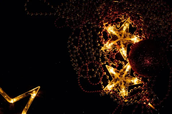 Parlak altın yıldızlar ve ışıl ışıl Noel süslemeleri. Noel ağacı oyuncakları Noel ve yeni yılı kutlamak için bir arzu yaratır. Tebrik kartları için grafik kaynağı.