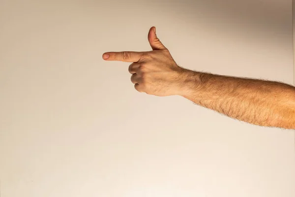 Silah olduğunu gösteren bir parmak hareketi. Başparmak havada, işaret parmağı önde, diğer parmaklar kenetlenmiş..