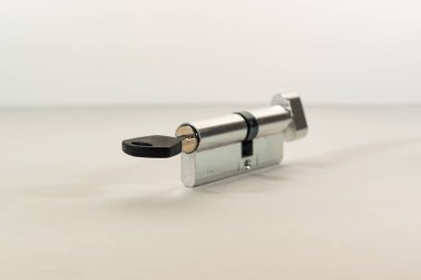 Anahtar anahtar deliğine yerleştirilir, hafif bir zemin üzerinde, ışık arkaplanı ile. Düz bir anahtar, kilitten bir larva, hafif bir arka plan. Gayrimenkul ve ipotek piyasasıyla ilgili.