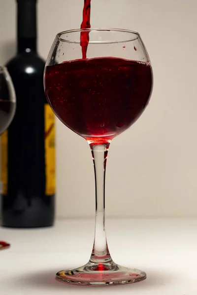 ガラスは クローズアップ 赤ワインで満たされている 赤ワイン ボトル ライトの背景とライトのボケのガラス 休日や夕食のためのポストカード — ストック写真
