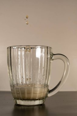 Beer mug filled with foamy, light beer. The glass is slightly filled with beer and foam. On the eve of a beer party and watching football.